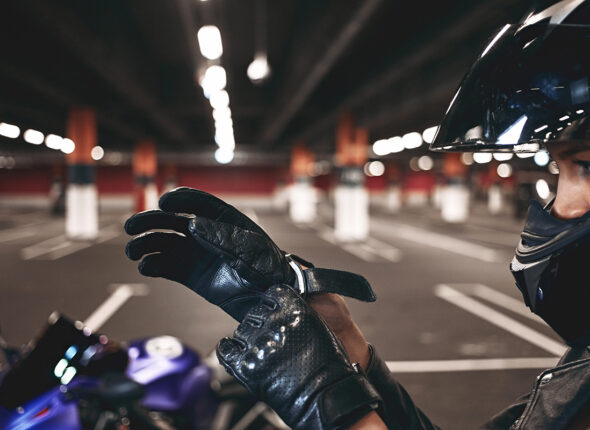 Confident young female racer wearing stylish motorcycle helmet p