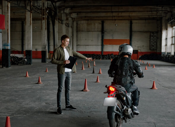 Instructor teaching young biker at personal lesson at motorcycle school